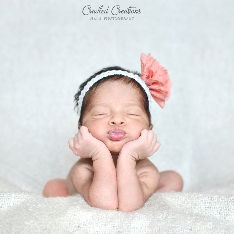 Newborn with hands under chin