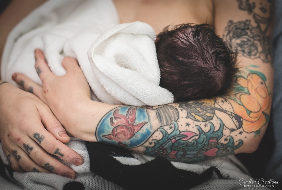 baby in mamas arms with tatoos